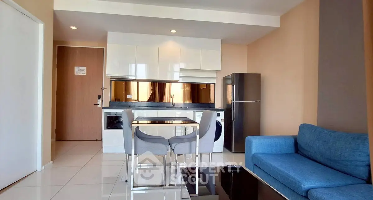 Modern open-layout kitchen and living room with sleek appliances and stylish furniture.
