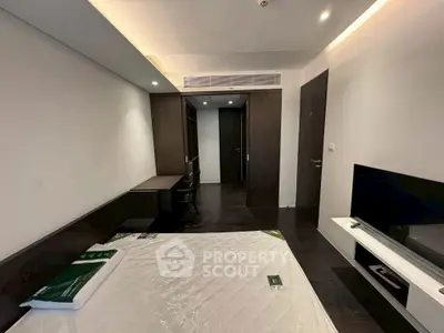 Modern bedroom with sleek furniture and built-in storage, featuring a minimalist design.