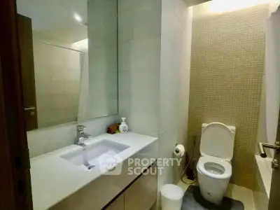 Modern bathroom with sleek fixtures and elegant tile design, featuring a spacious vanity and contemporary toilet.