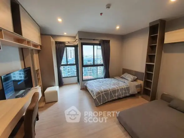 Modern bedroom with city view, featuring stylish furniture and ample natural light.
