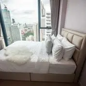Luxurious bedroom with stunning city view and plush bedding in high-rise apartment.