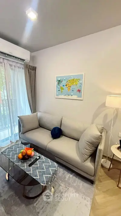 Chic living room with modern sofa, stylish decor, and natural light from large window.