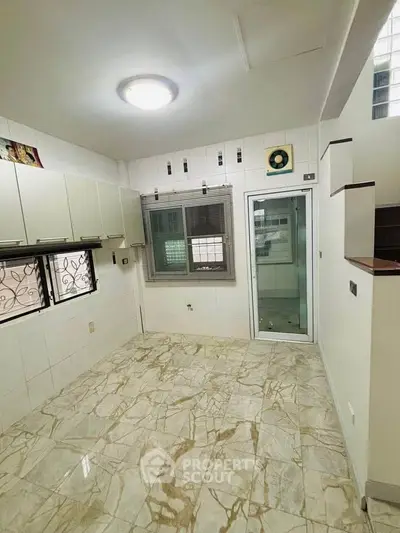 Spacious kitchen with marble flooring and ample natural light