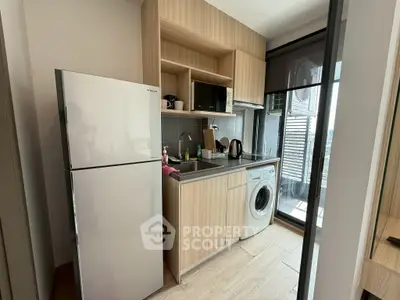 Modern compact kitchen with appliances and balcony view