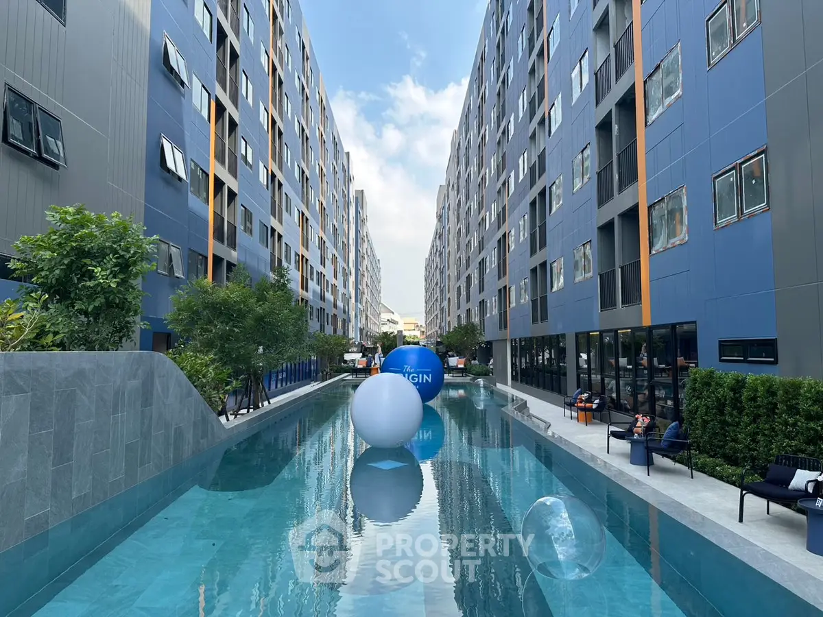Modern apartment complex with a central swimming pool and contemporary design.