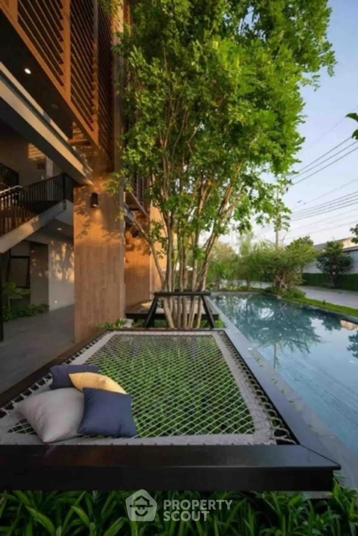 Luxurious outdoor area with hammock and poolside view, perfect for relaxation and leisure.