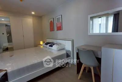 Modern bedroom with stylish decor and cozy ambiance, featuring a comfortable bed and a sleek desk area.