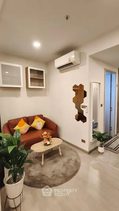 Modern living room with stylish decor and cozy seating area, featuring air conditioning and elegant wall accents.