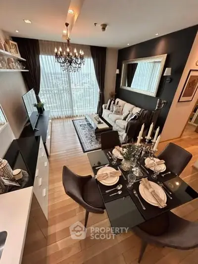 Elegant living room with dining area, chandelier, and large window view in modern apartment.