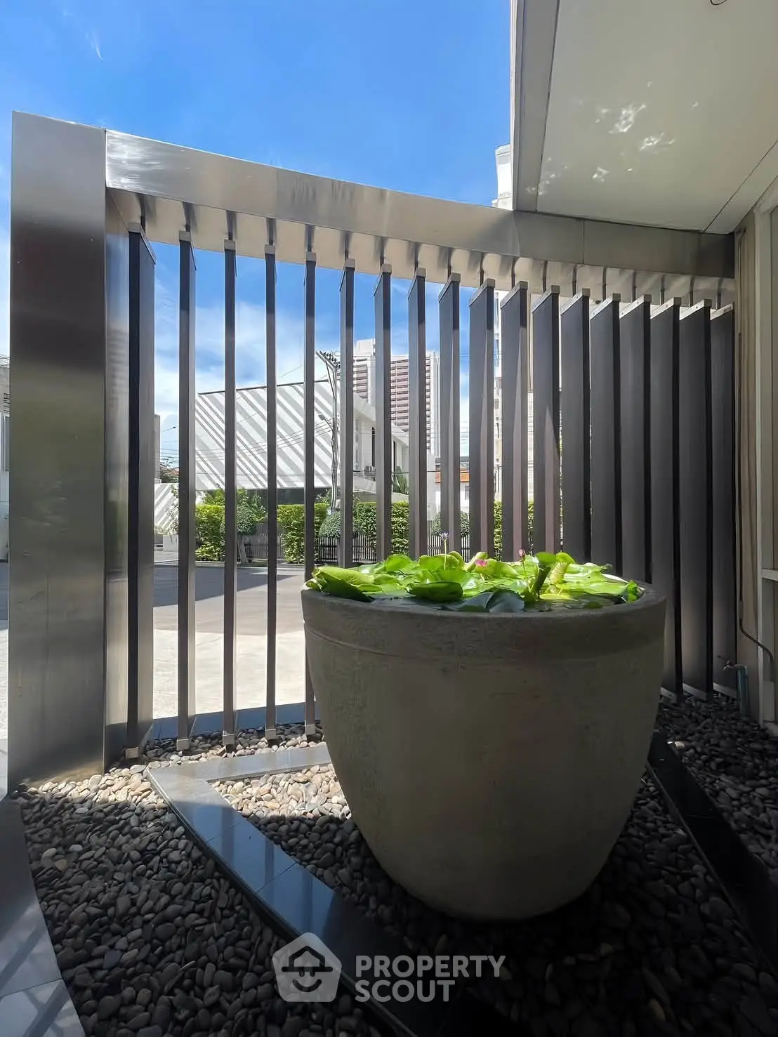 Modern outdoor space with sleek metal fence and decorative planter, perfect for urban living.