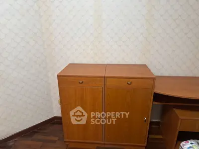 Cozy study room with wooden cabinets and desk, perfect for home office setup.