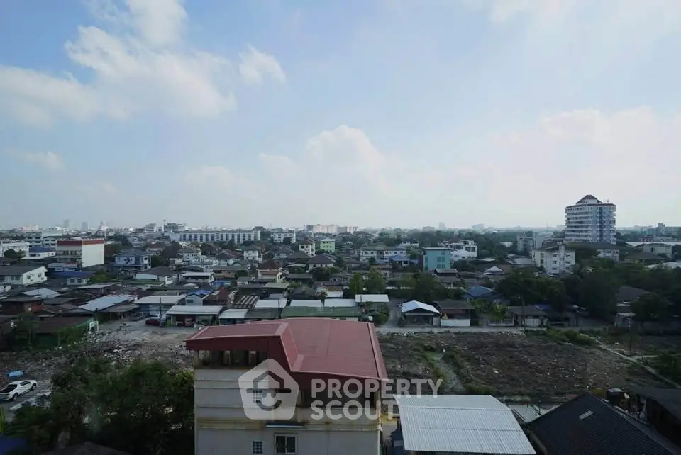 Panoramic cityscape view showcasing urban residential area with clear skies and distant buildings.