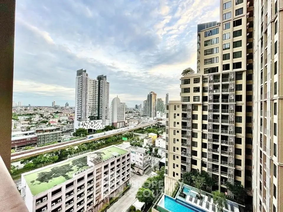 Stunning cityscape view from high-rise apartment with pool and modern architecture.
