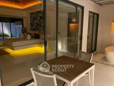 Luxurious modern bedroom with ambient lighting and outdoor seating area.