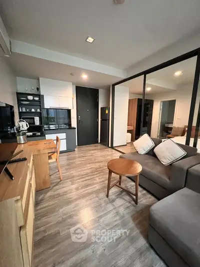 Modern open-plan living room with sleek kitchen and cozy seating area