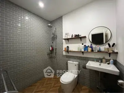 Modern bathroom with stylish gray tiles and wooden floor