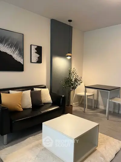 Modern living room with stylish decor, black leather sofa, and cozy dining area, perfect for urban living.