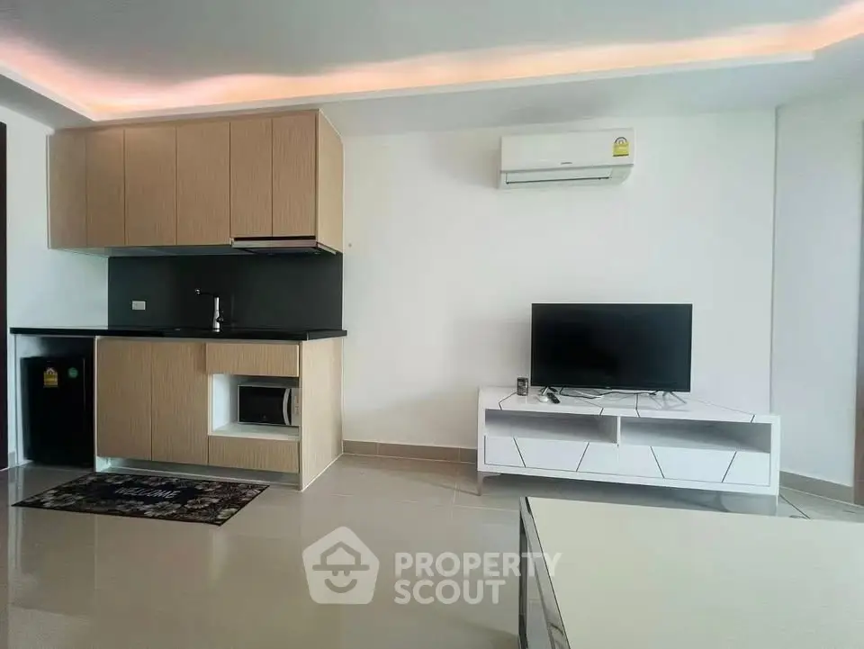 Modern living room with sleek kitchenette and air conditioning unit, perfect for urban living.