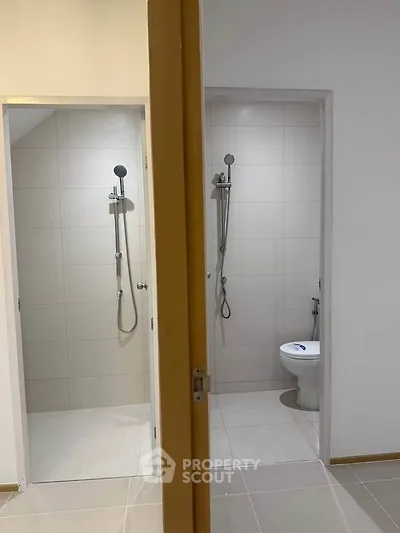 Modern dual bathroom setup with sleek shower fixtures and minimalist design.