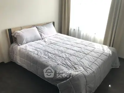 Cozy bedroom with natural light and modern decor, perfect for relaxation.