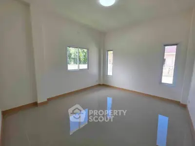 Spacious empty room with large windows and glossy tiled floor, perfect for customization.