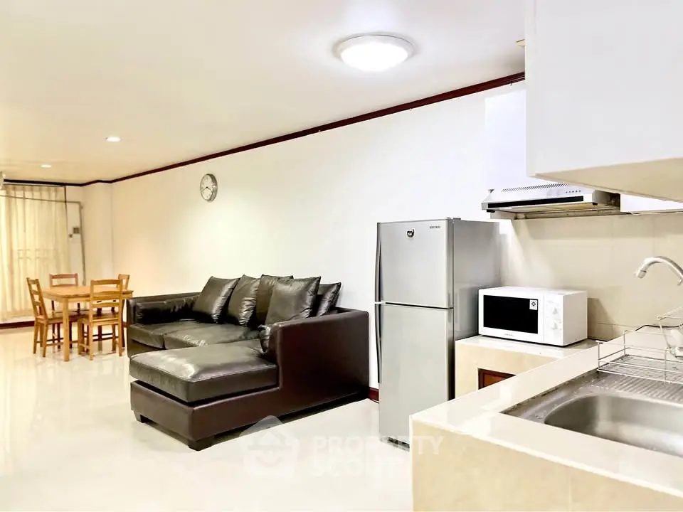 Spacious living room with modern kitchen appliances and cozy seating area