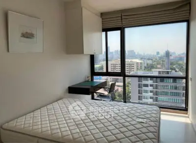 Modern bedroom with city view, featuring large windows and minimalist decor.