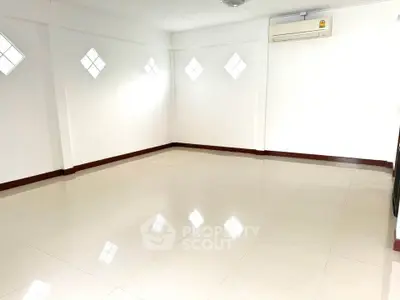 Spacious unfurnished room with glossy tiled floor and air conditioning
