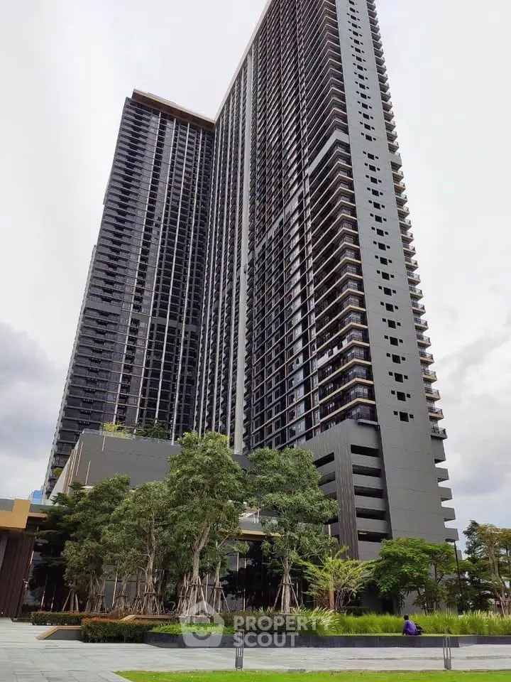 Stunning modern high-rise building with lush landscaping and sleek architectural design.