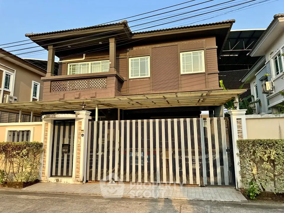 Charming two-story house with gated entrance and balcony in a serene neighborhood.
