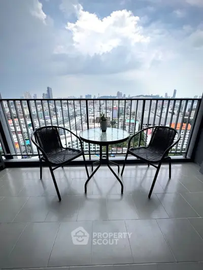 Stunning high-rise balcony with panoramic city views and cozy seating area.