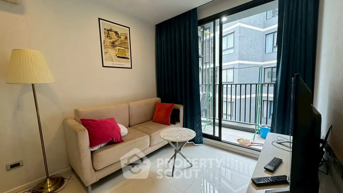 Cozy living room with modern decor and balcony view in urban apartment.