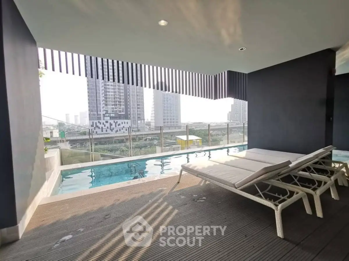 Luxurious rooftop pool with city skyline view and modern lounge chairs.