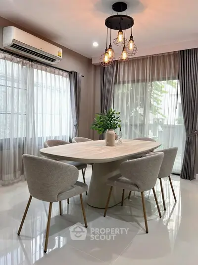 Elegant dining area with modern chandelier and stylish furniture in a bright, airy room.