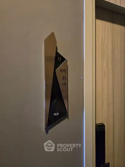 Modern apartment door with sleek metallic room number plaque