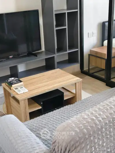 Modern living room with cozy sofa, TV, and stylish wooden coffee table in a chic apartment.