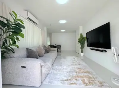 Spacious modern living room with sleek decor and large wall-mounted TV
