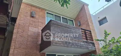 Modern building exterior with brick facade and wooden balcony