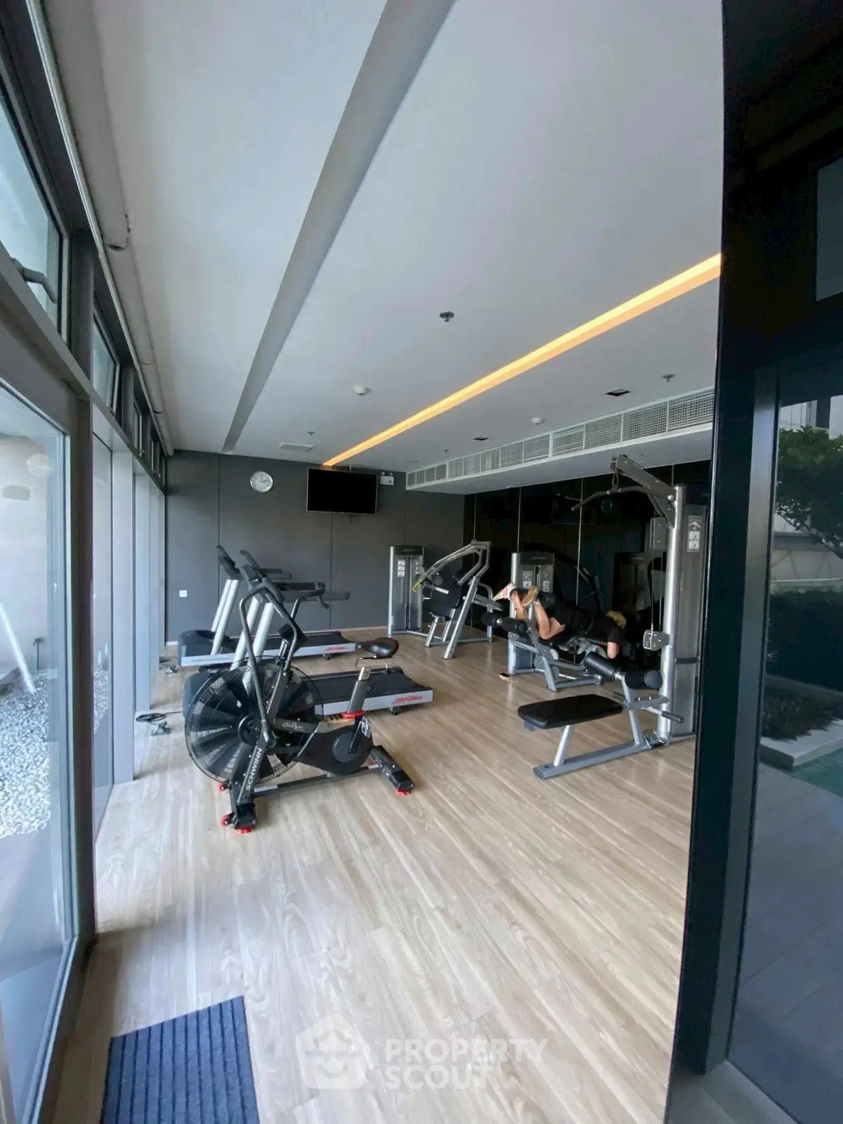 Modern gym with state-of-the-art equipment and large windows for natural light.