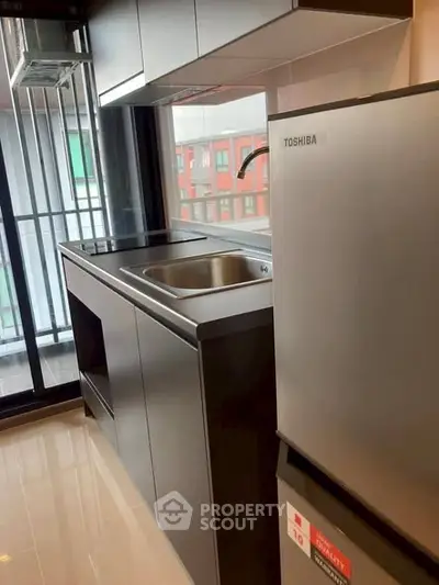 Modern kitchen with sleek cabinets and stainless steel appliances in a compact layout.