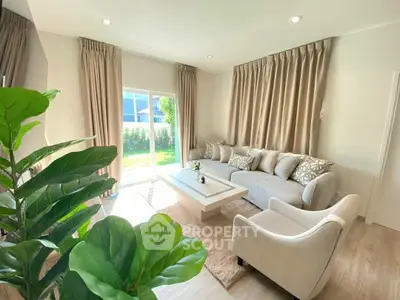 Elegant living room with plush sofa, large windows, and lush garden view, perfect for relaxation and entertaining.