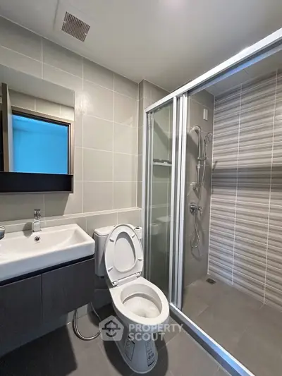 Modern bathroom with sleek shower and contemporary fixtures in a stylish apartment.