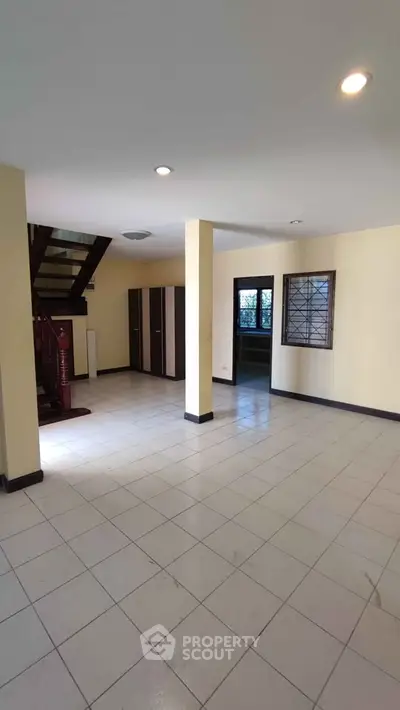 Spacious open-plan living area with staircase and natural light