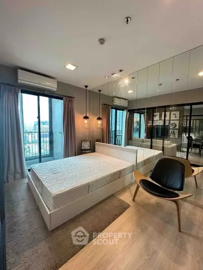 Modern bedroom with mirrored wall and balcony view in luxury apartment