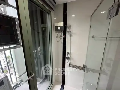 Modern bathroom with glass shower and balcony view in urban apartment