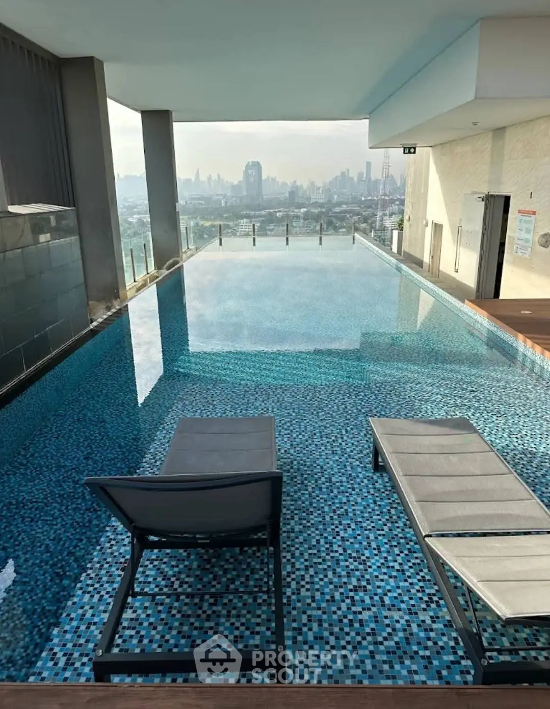 Luxurious rooftop pool with stunning city skyline view, perfect for relaxation and leisure.