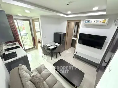 Modern living room with open kitchen and balcony access in a stylish apartment.