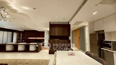 Modern open-plan living and dining area with sleek kitchen appliances and elegant decor.