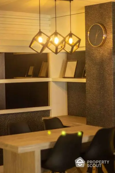 Modern dining area with stylish lighting and wall clock