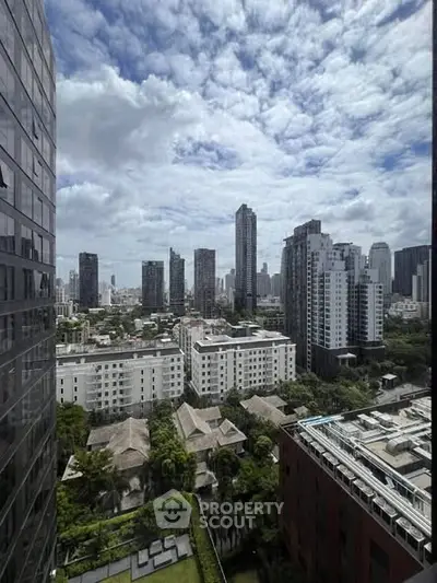 Stunning cityscape view from high-rise building showcasing urban skyline and lush greenery.